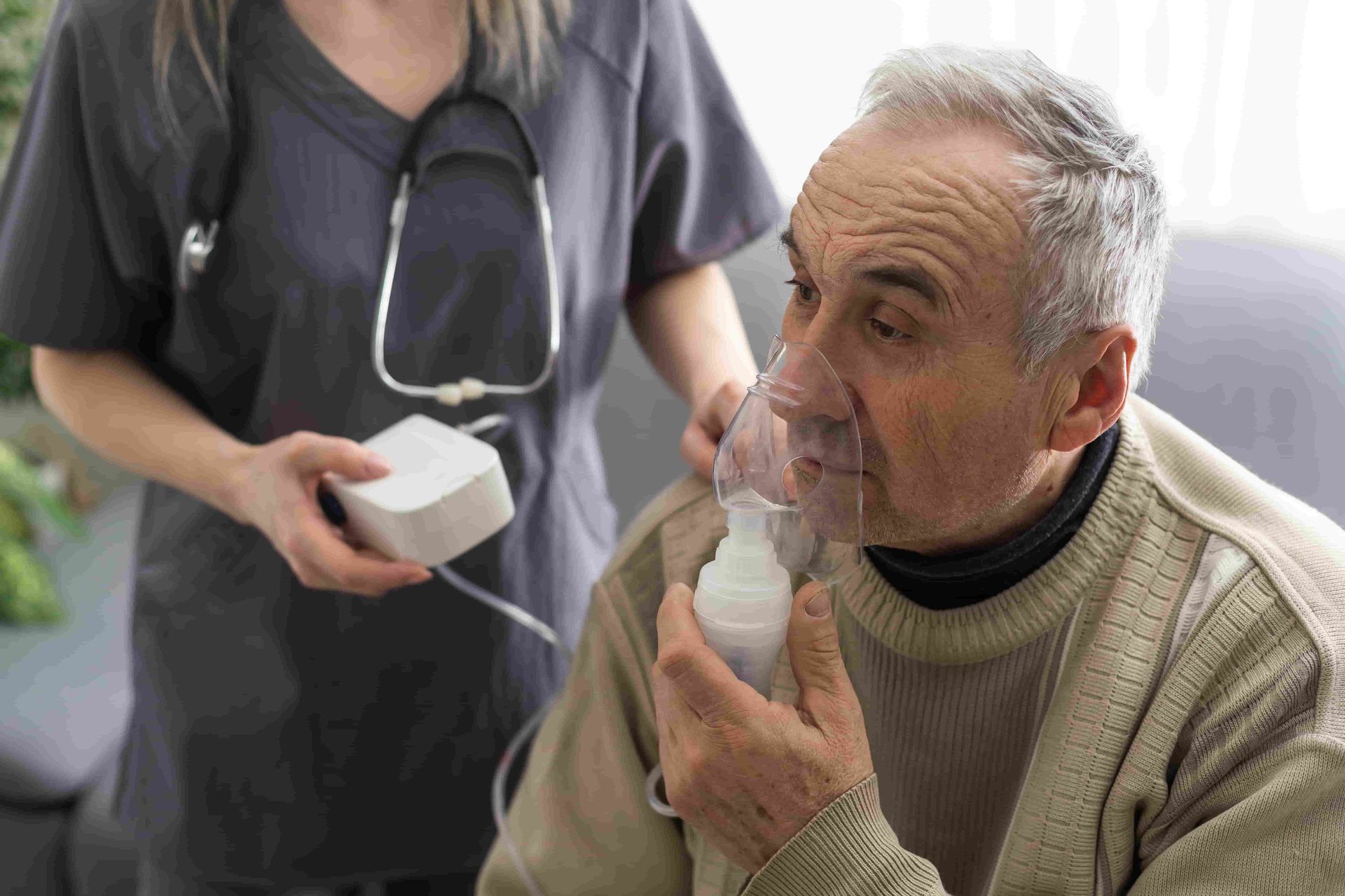 An Elderly Man Is Getting an Oxygen Mask from A Nurse — Tuncurry Medical Centre In Tuncurry, NSW