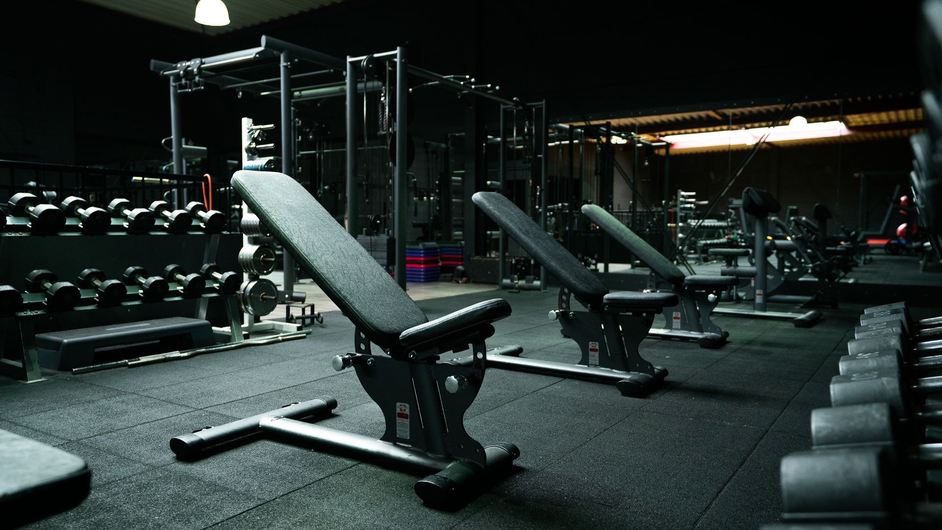 Een sportschool met veel halters en banken