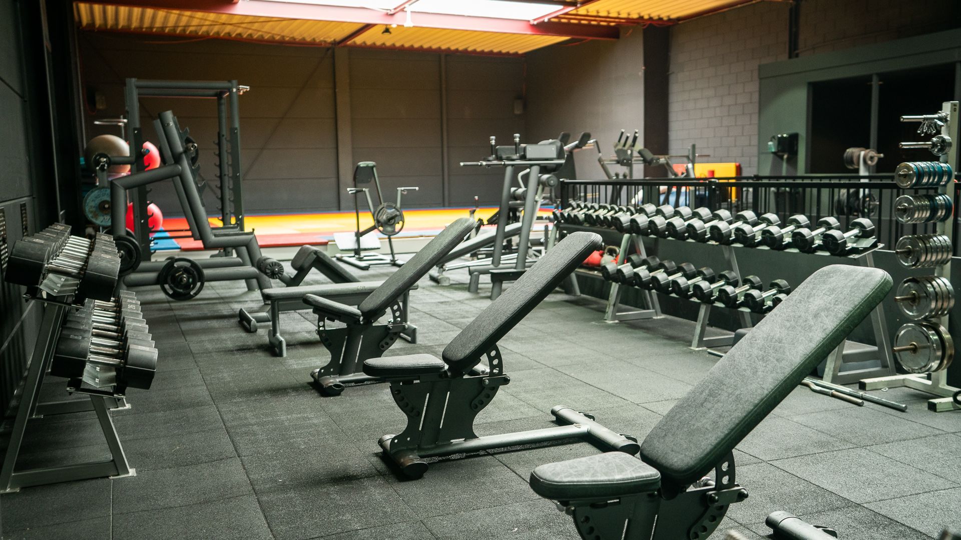 Een sportschool met veel halters en banken