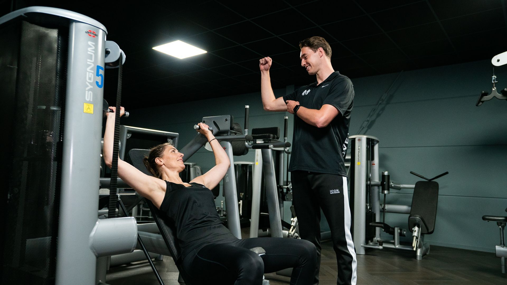 Een man helpt een vrouw met oefeningen op de grond.