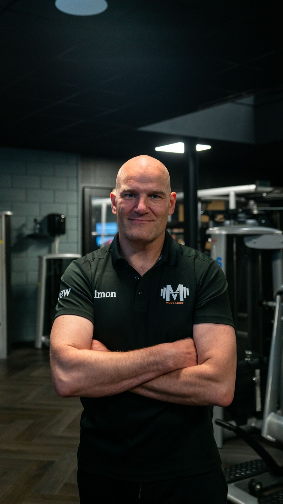 Een man en een vrouw poseren voor een foto in een sportschool.