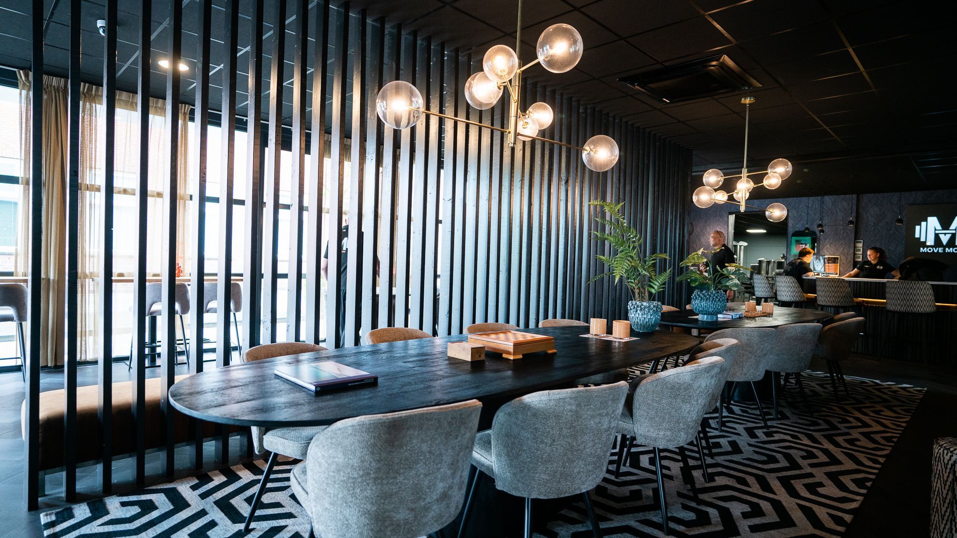 Er staat een lange tafel met stoelen in de kamer.