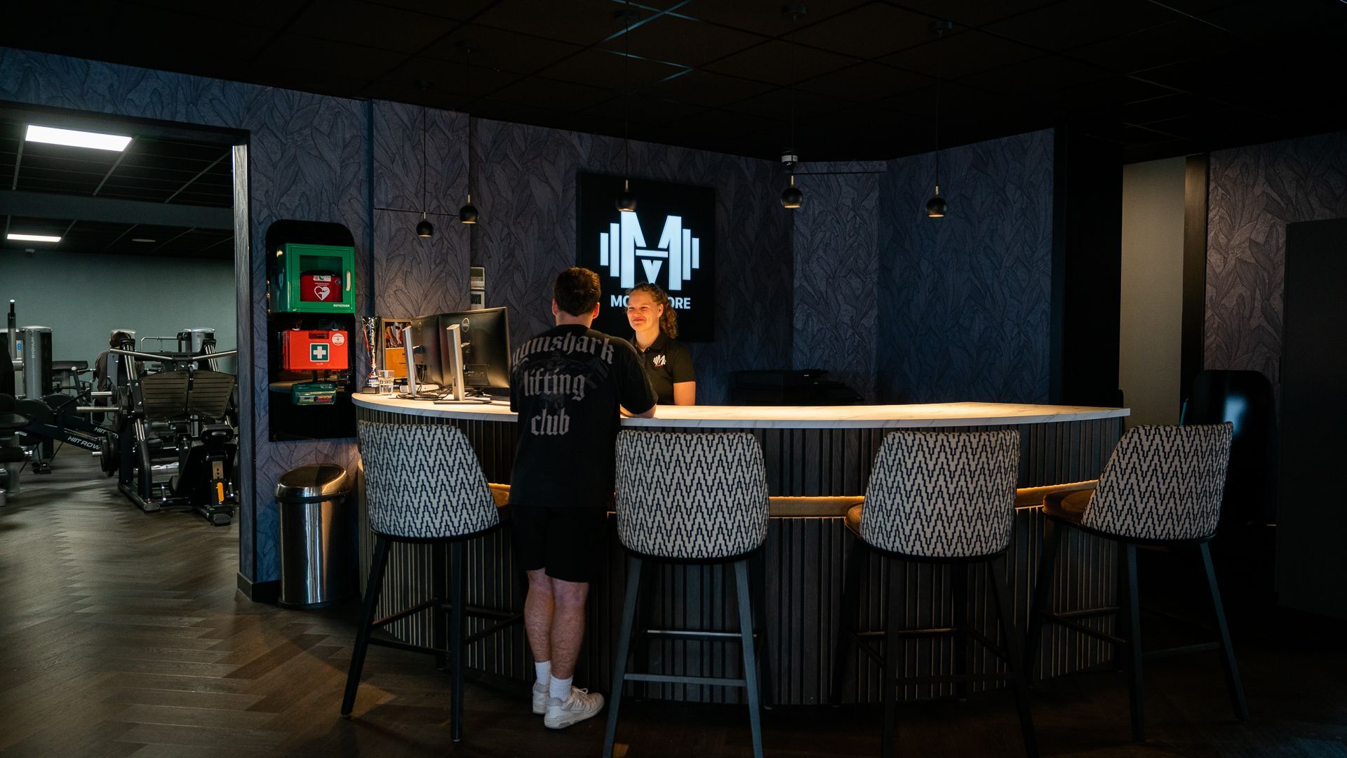 Een losse halter ligt op de grond in een sportschool.