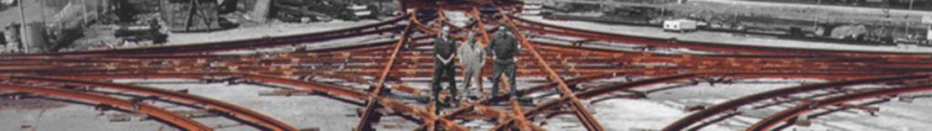 A blurred image of a bridge with a few trees in the background.