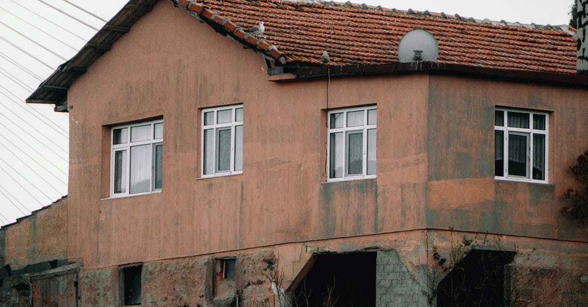 a man installing a gutter on the side of a house