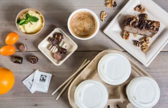 Colazione servita su un tavolo di legno: caffè, pasticcini, frutta e tè.
