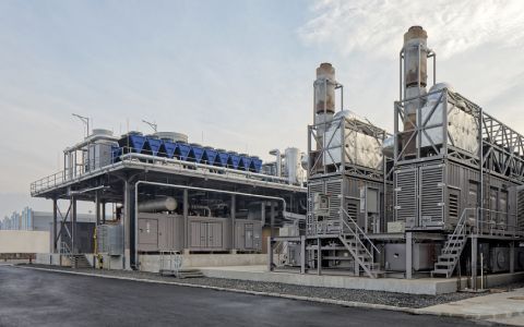 A large industrial building with a lot of pipes and stairs.