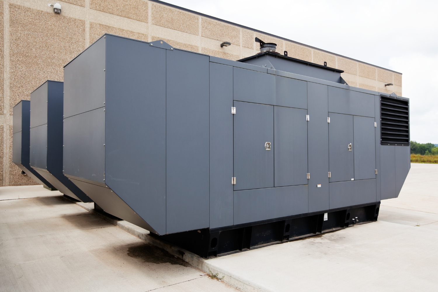 A large gray container is parked in front of a building.