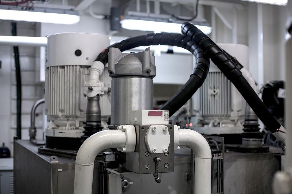 Industrial machinery with two white motors and pipes, in a marine setting.