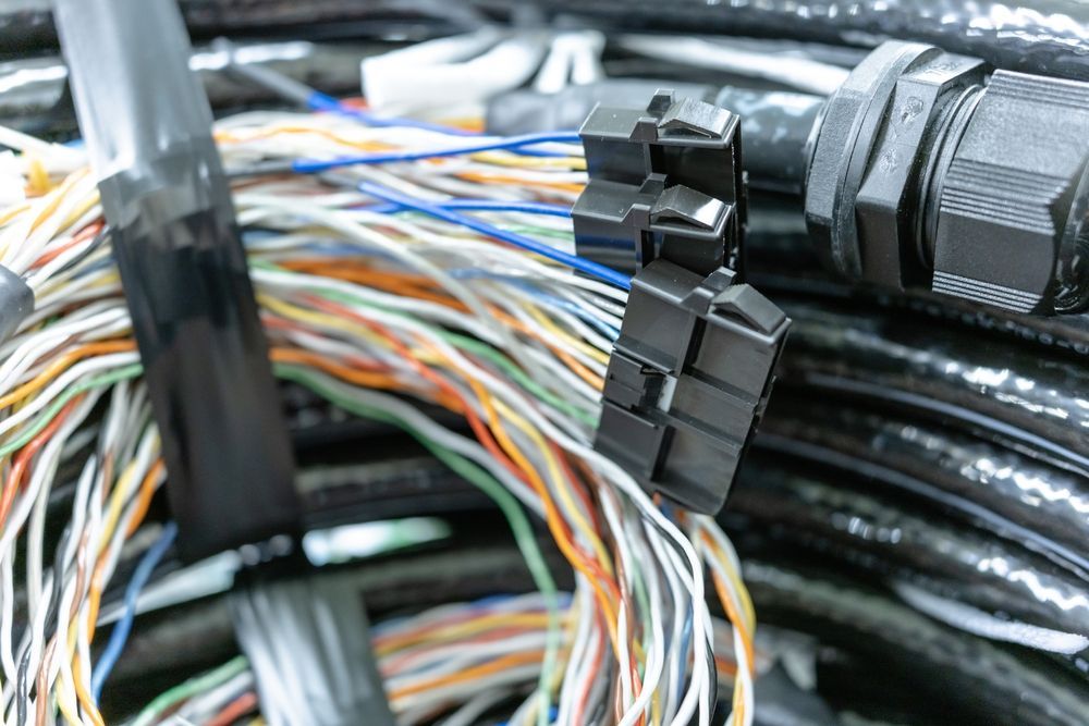 Close-up of a bundle of colorful electrical wires with a black connector.