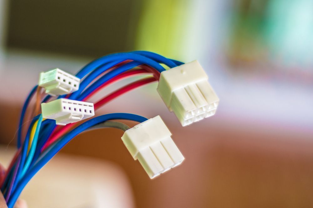 Close-up of colored electrical wires with white plastic connectors.