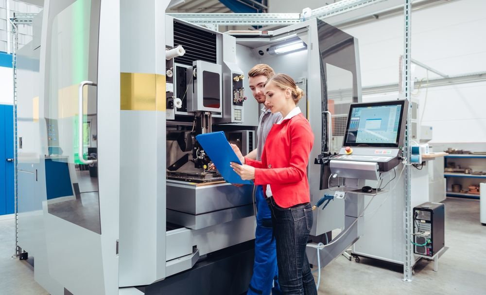 manufacturers standing and talking to each other in front of a wire processing machine similar to the Komax Zeta