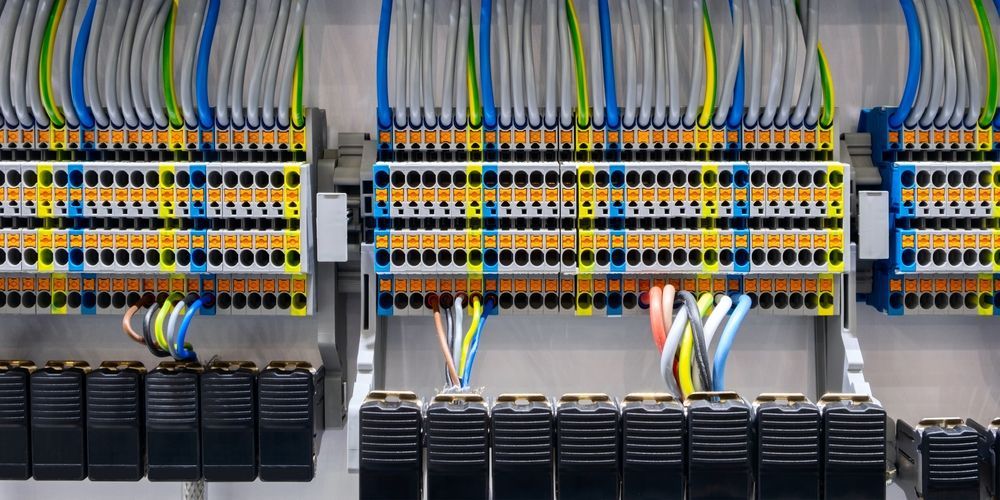 Electrical wiring panel with colorful wires connected to terminals.