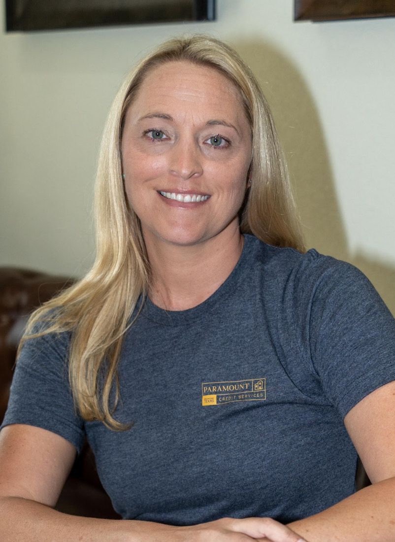 A woman wearing a blue shirt is smiling for the camera.