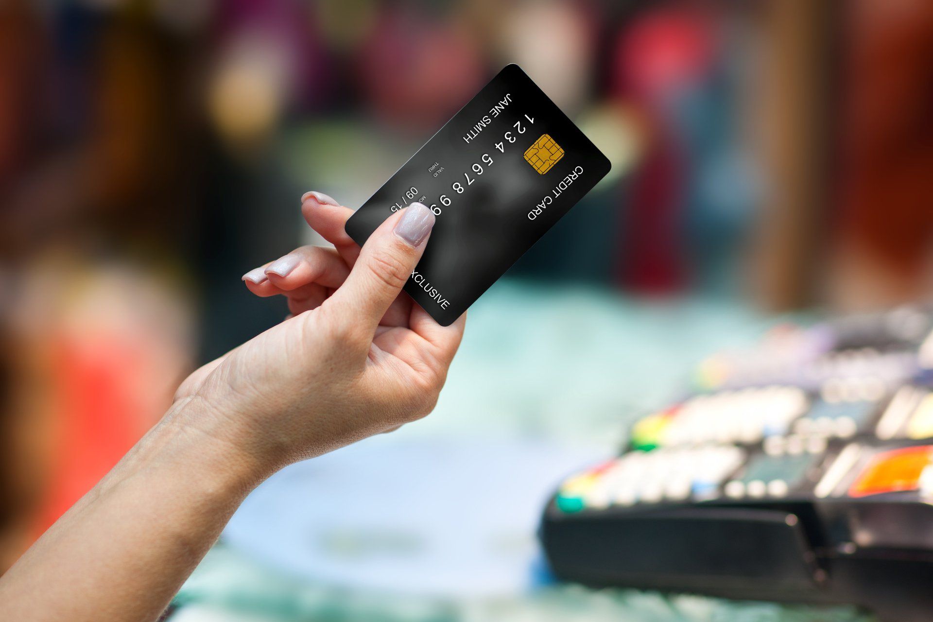 A woman is holding a credit card in her hand.