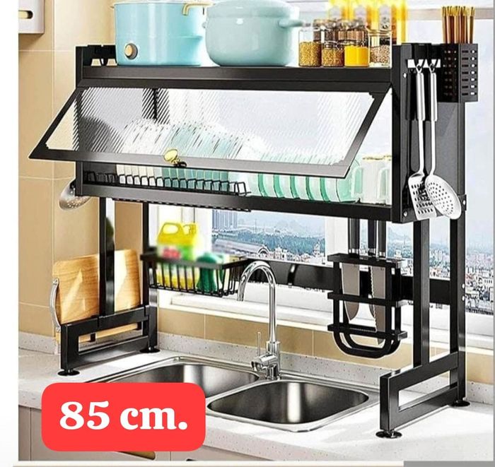 Escurreplatos negro sobre un fregadero, con capacidad para platos, utensilios y baterías de cocina