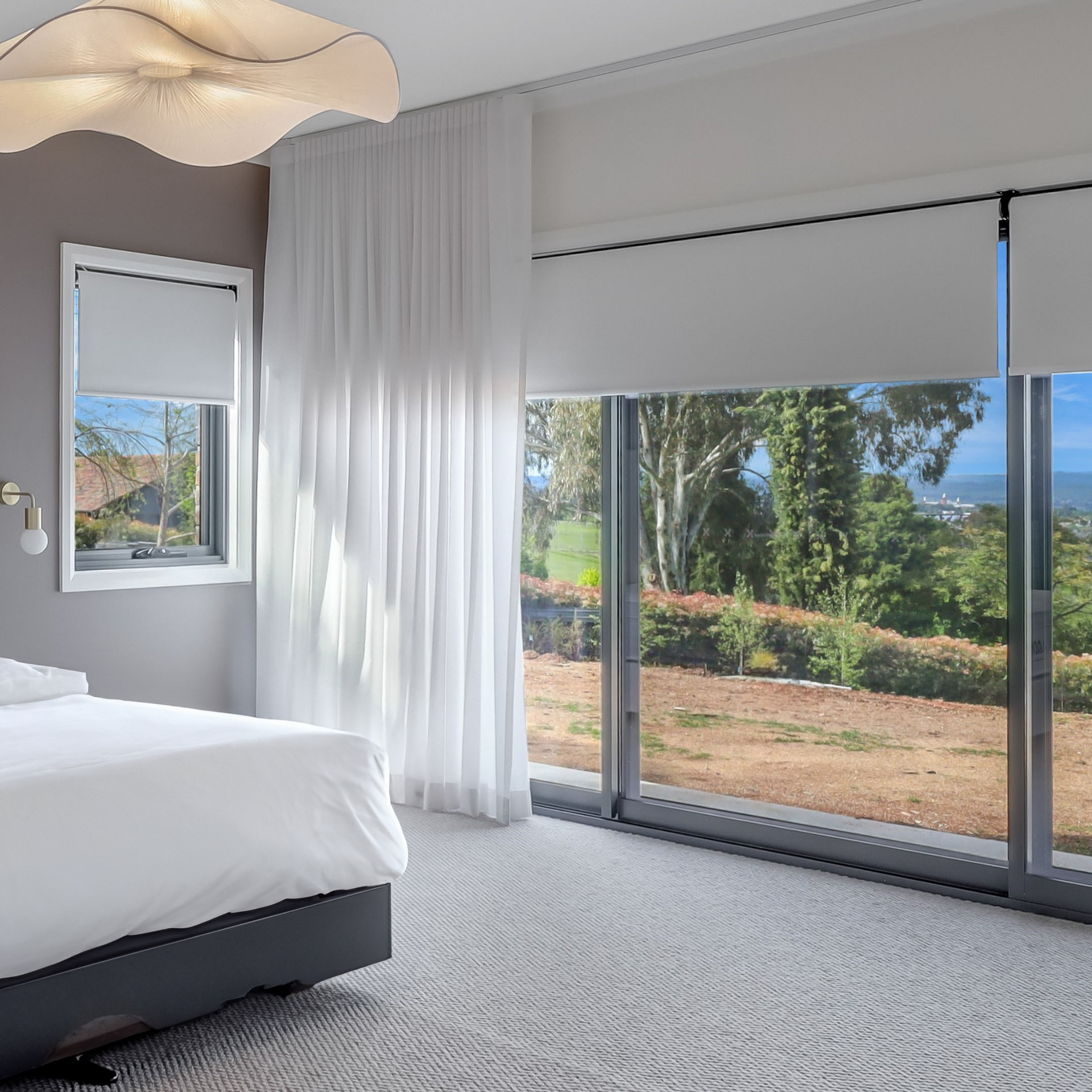 A bedroom with a large window and a bed