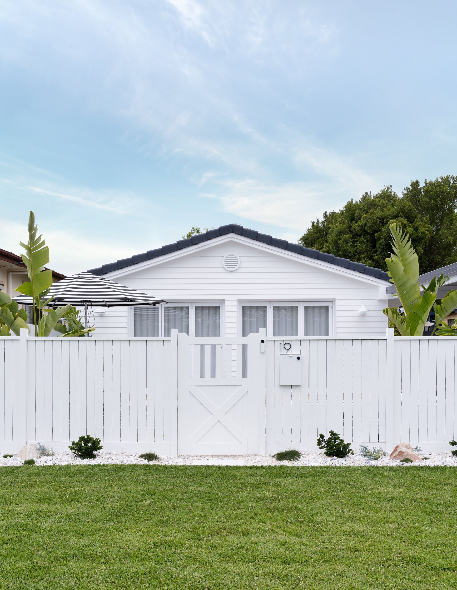 A white house with a white fence in front of it.