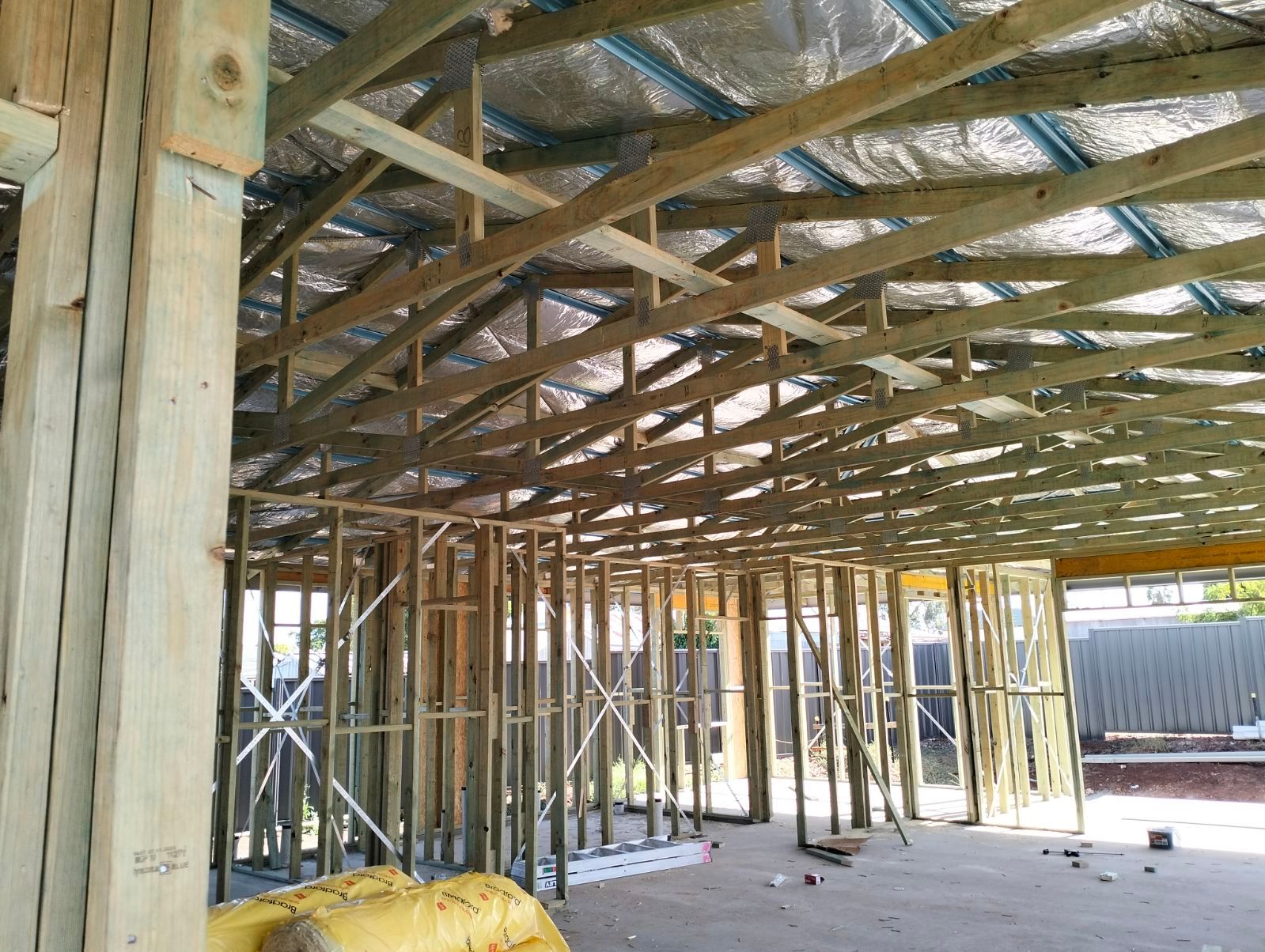 The inside of a building under construction with a lot of wooden beams.