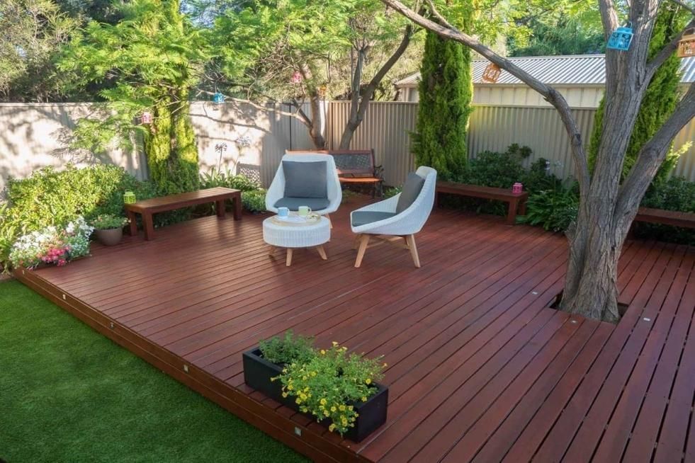 A wooden deck with chairs and a table on it