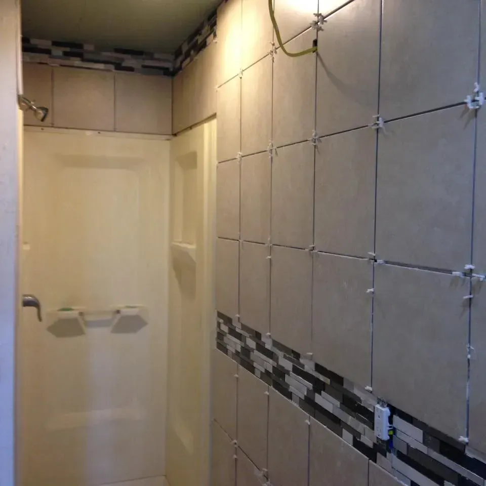 A bathroom with tiled walls and a shower stall