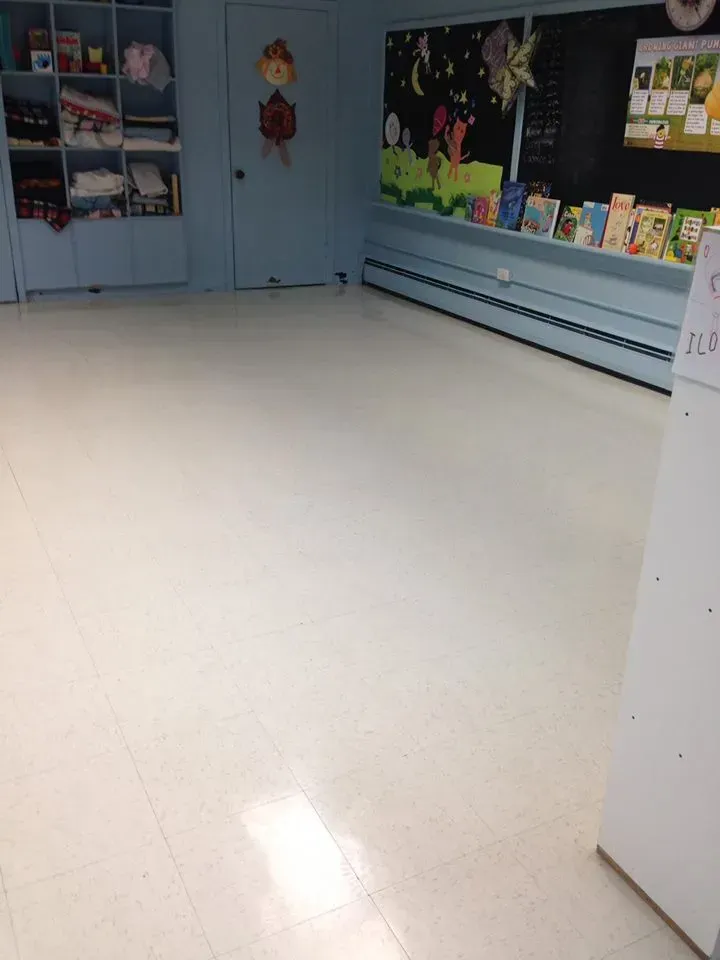 A classroom with a chalkboard and books on shelves