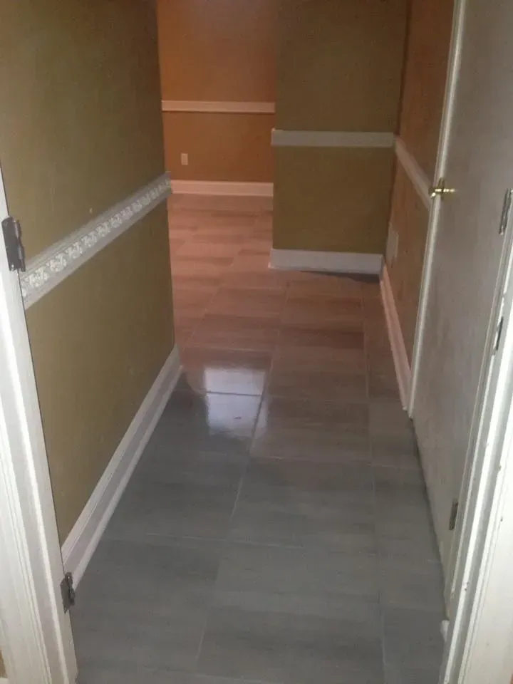 A hallway with hardwood floors and a door in a house.