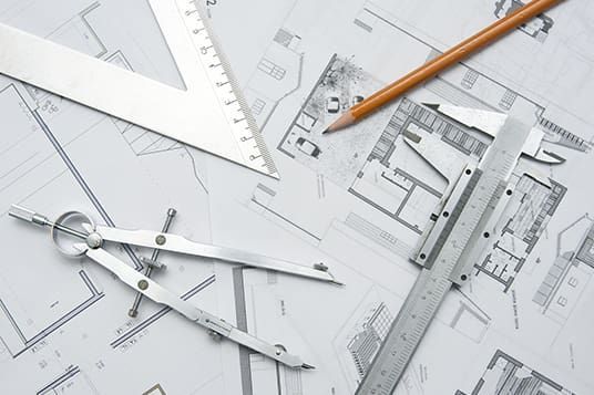 A ruler , compass , and pencil are on top of a drawing of a house.