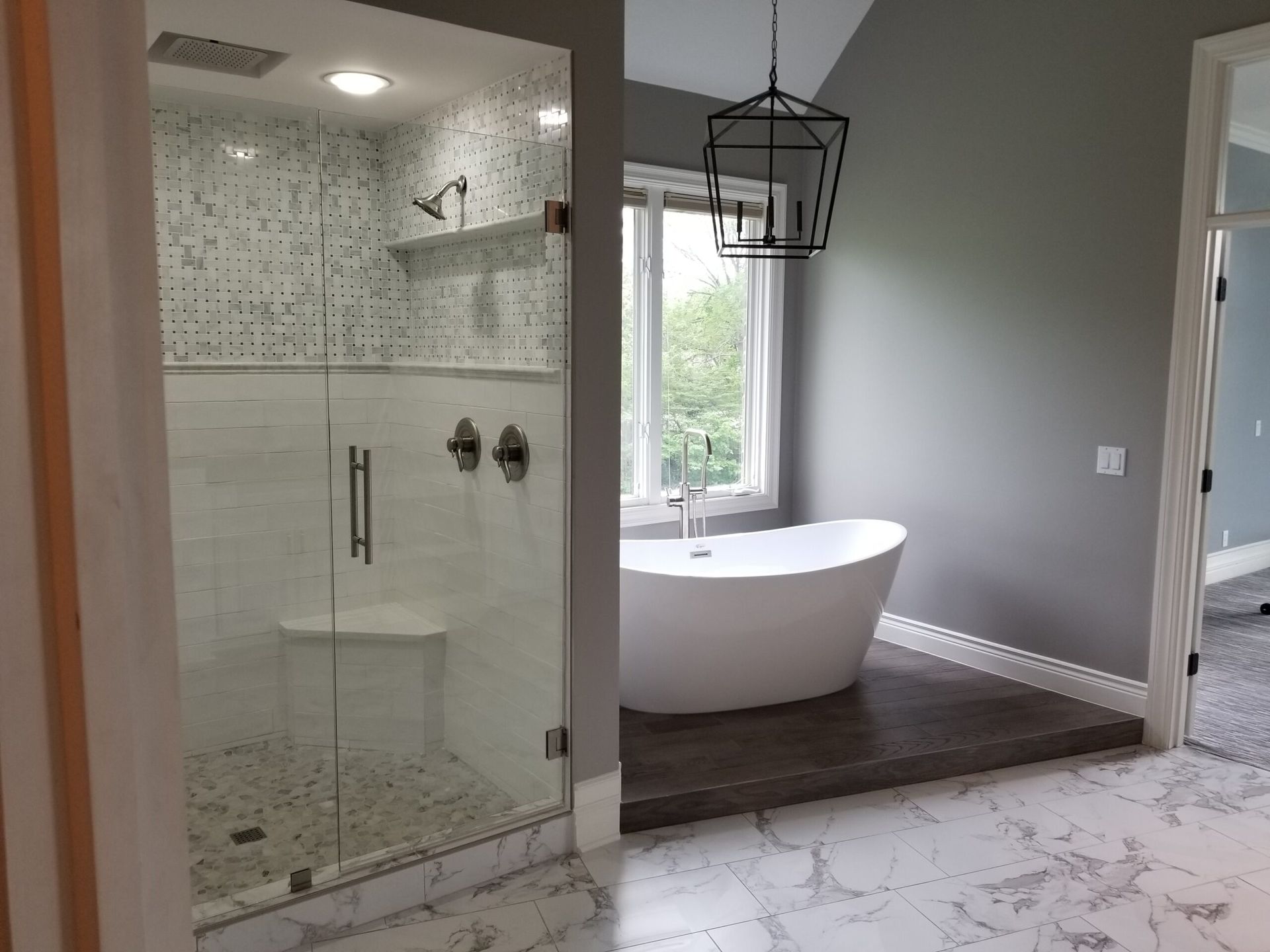 A bathroom with a tub , shower , and window.