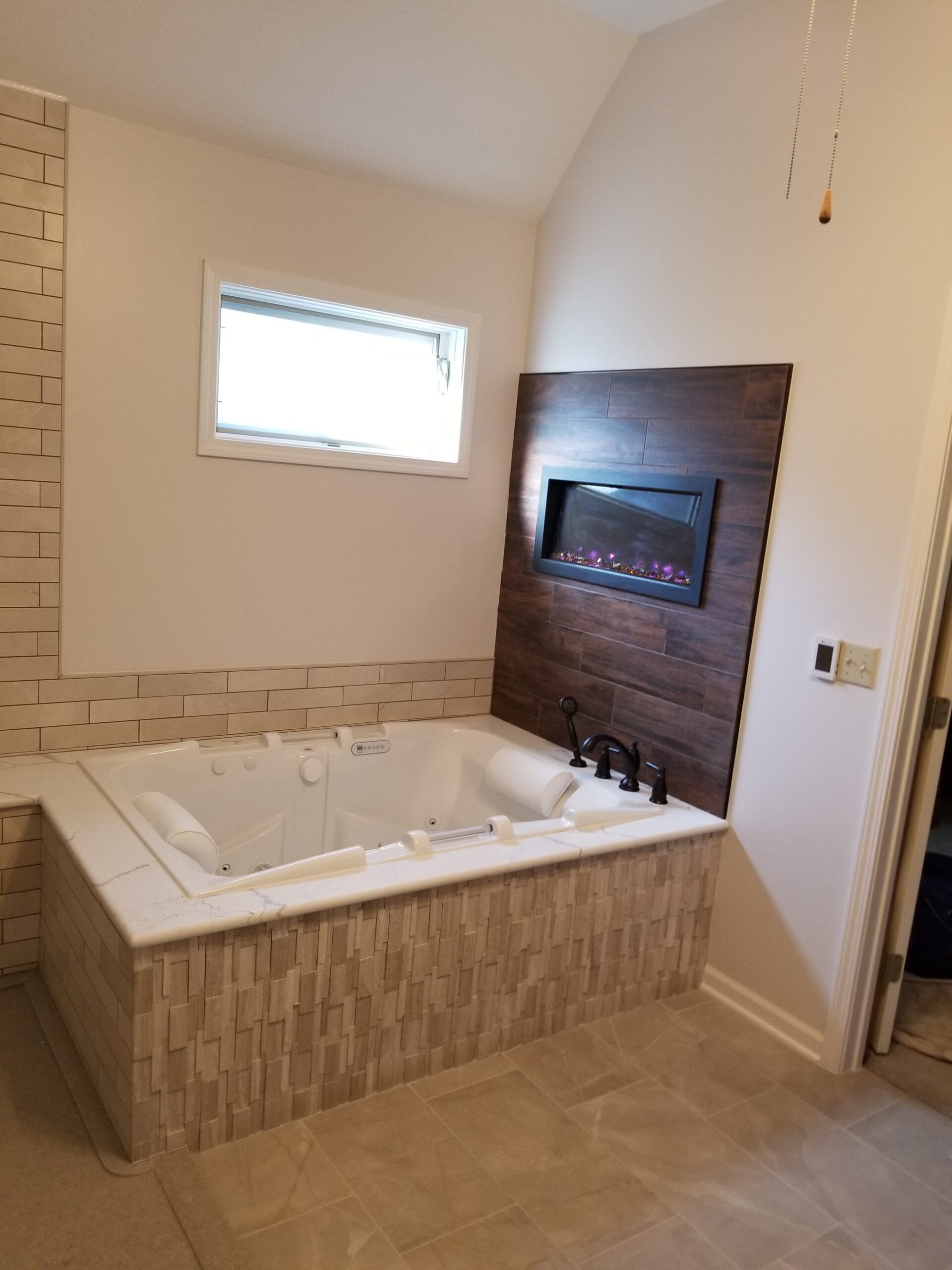 A bathroom with a jacuzzi tub and a fireplace.