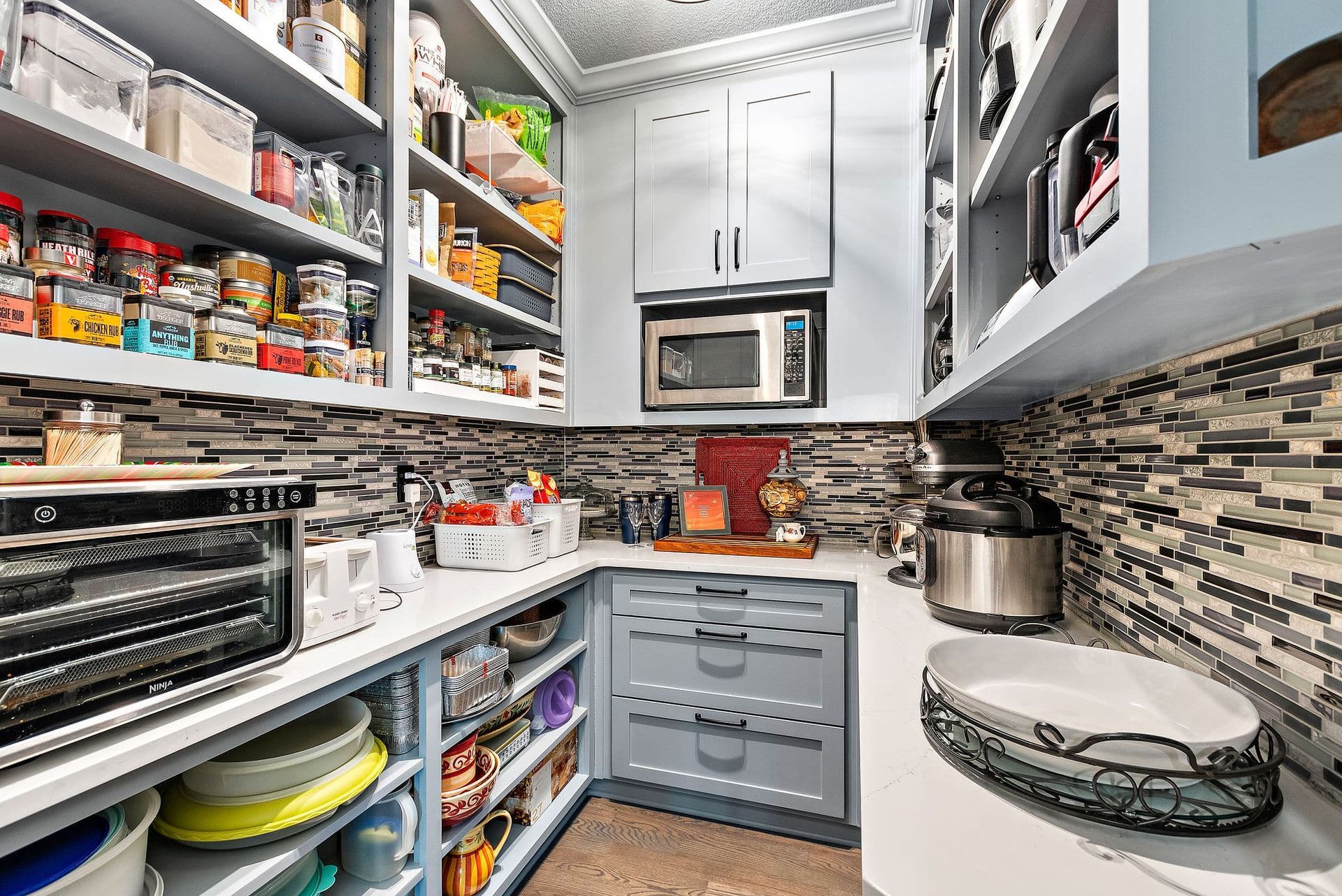 A kitchen pantry filled with lots of food and appliances.