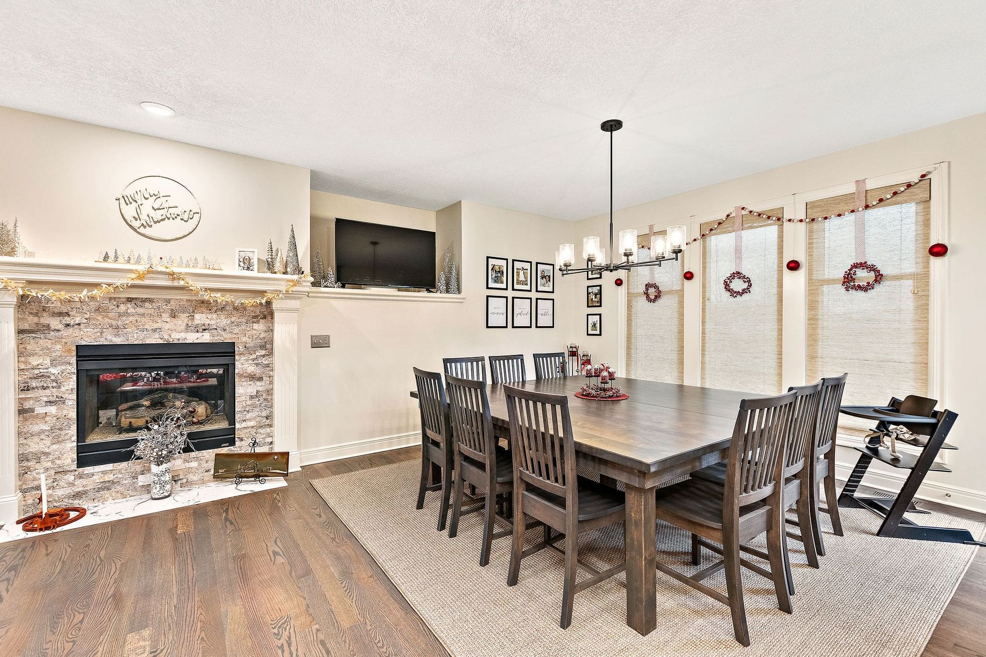 A dining room with a table and chairs and a fireplace.