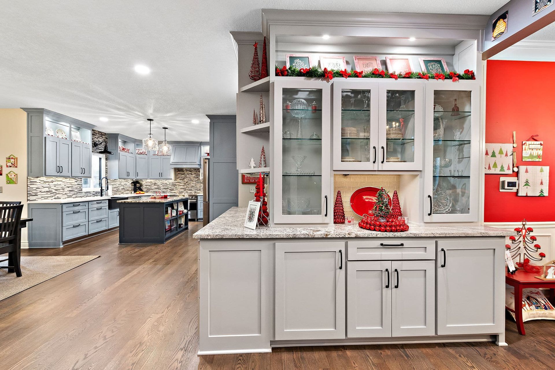 A kitchen with a lot of cabinets and a red wall.