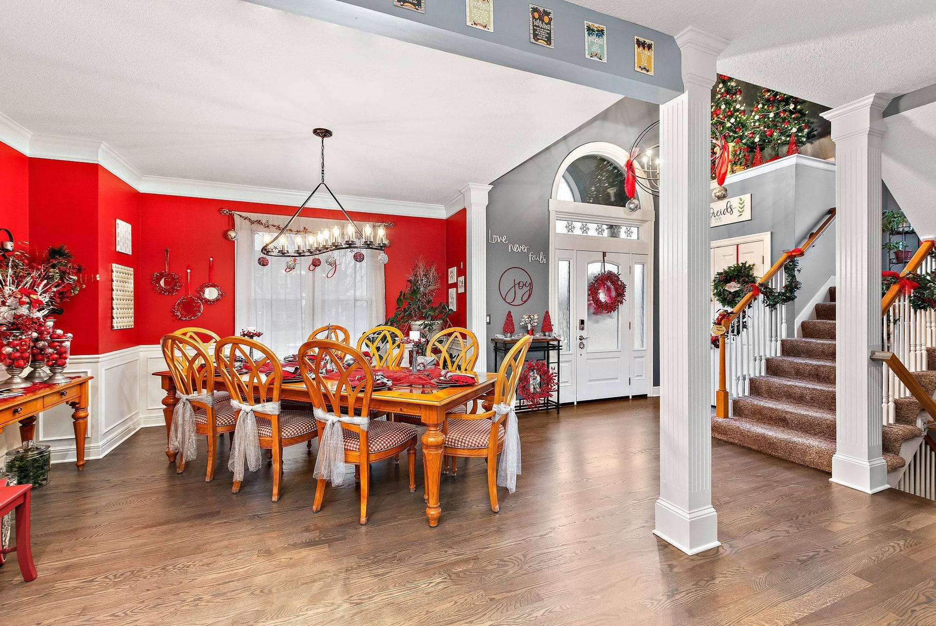 A large dining room with a table and chairs decorated for christmas.