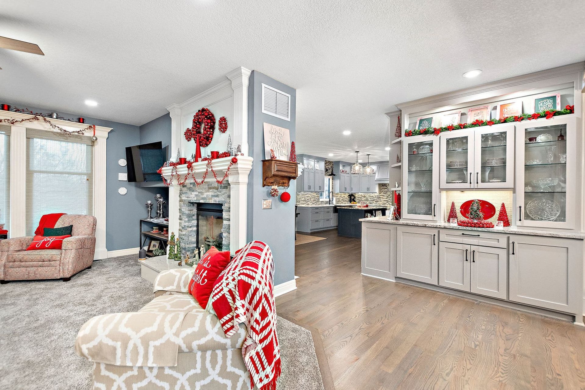 A living room filled with furniture and a fireplace decorated for christmas.