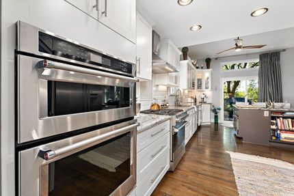 A kitchen with stainless steel appliances and white cabinets.