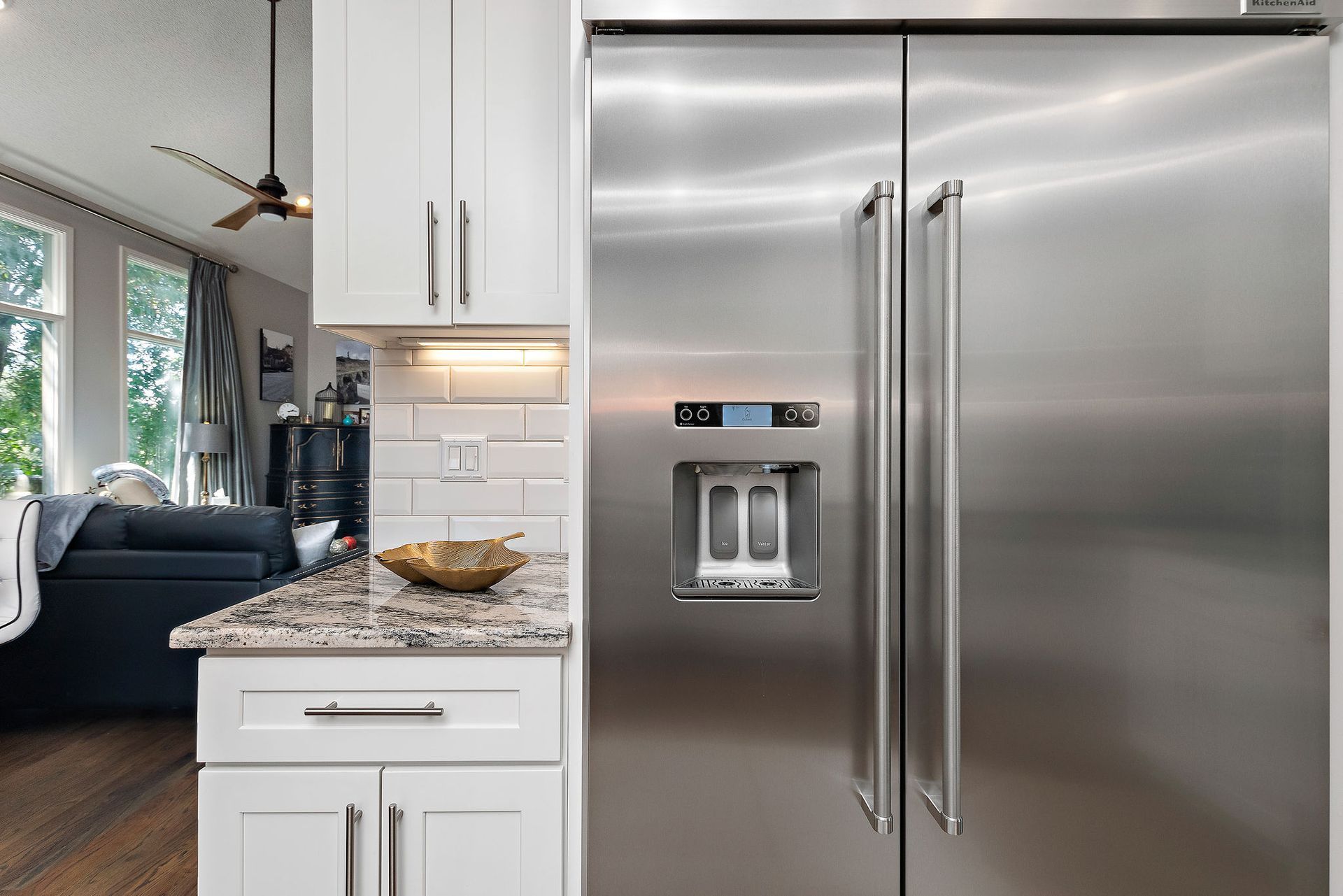 A kitchen with stainless steel appliances and white cabinets.