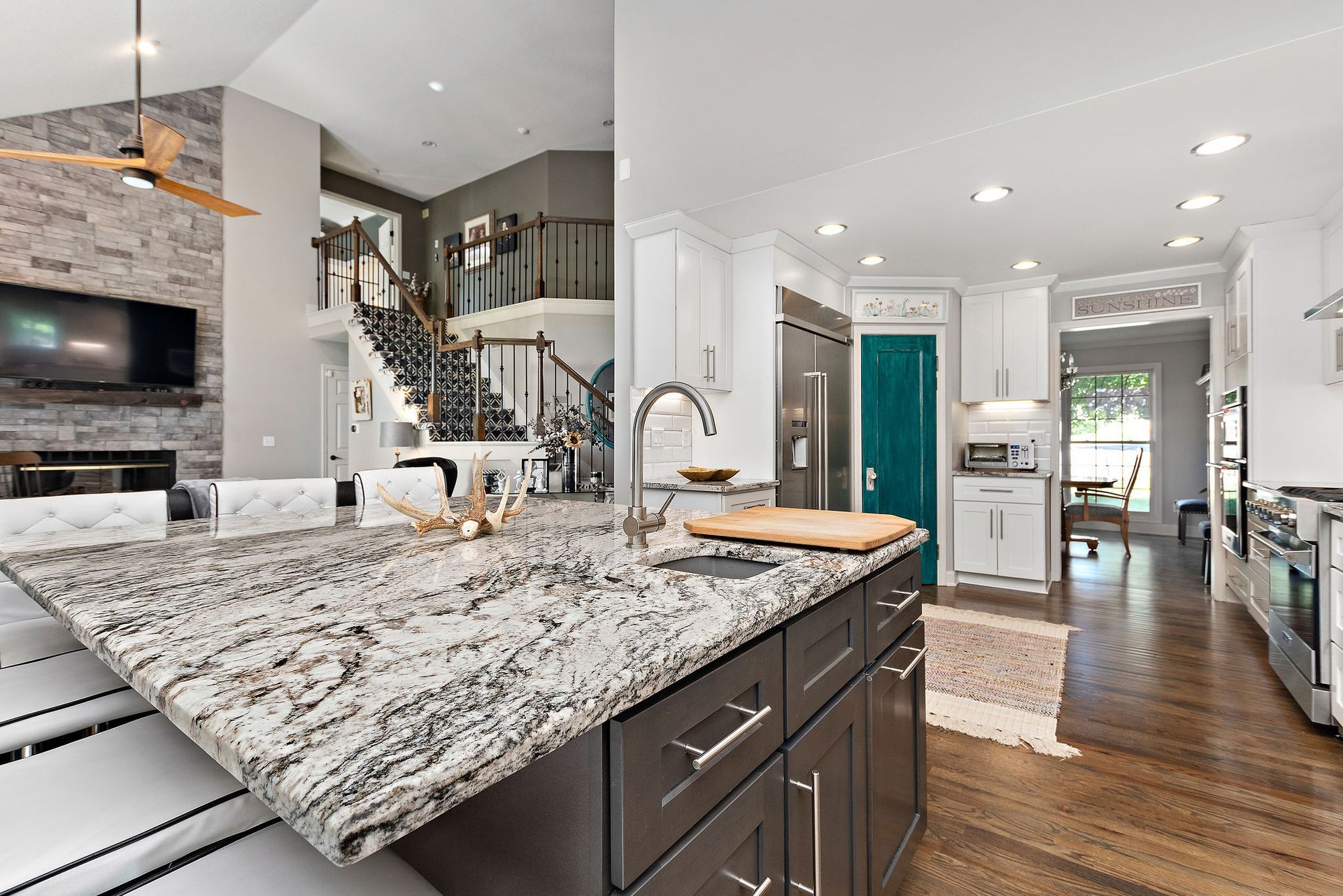 A kitchen with granite counter tops and stainless steel appliances.