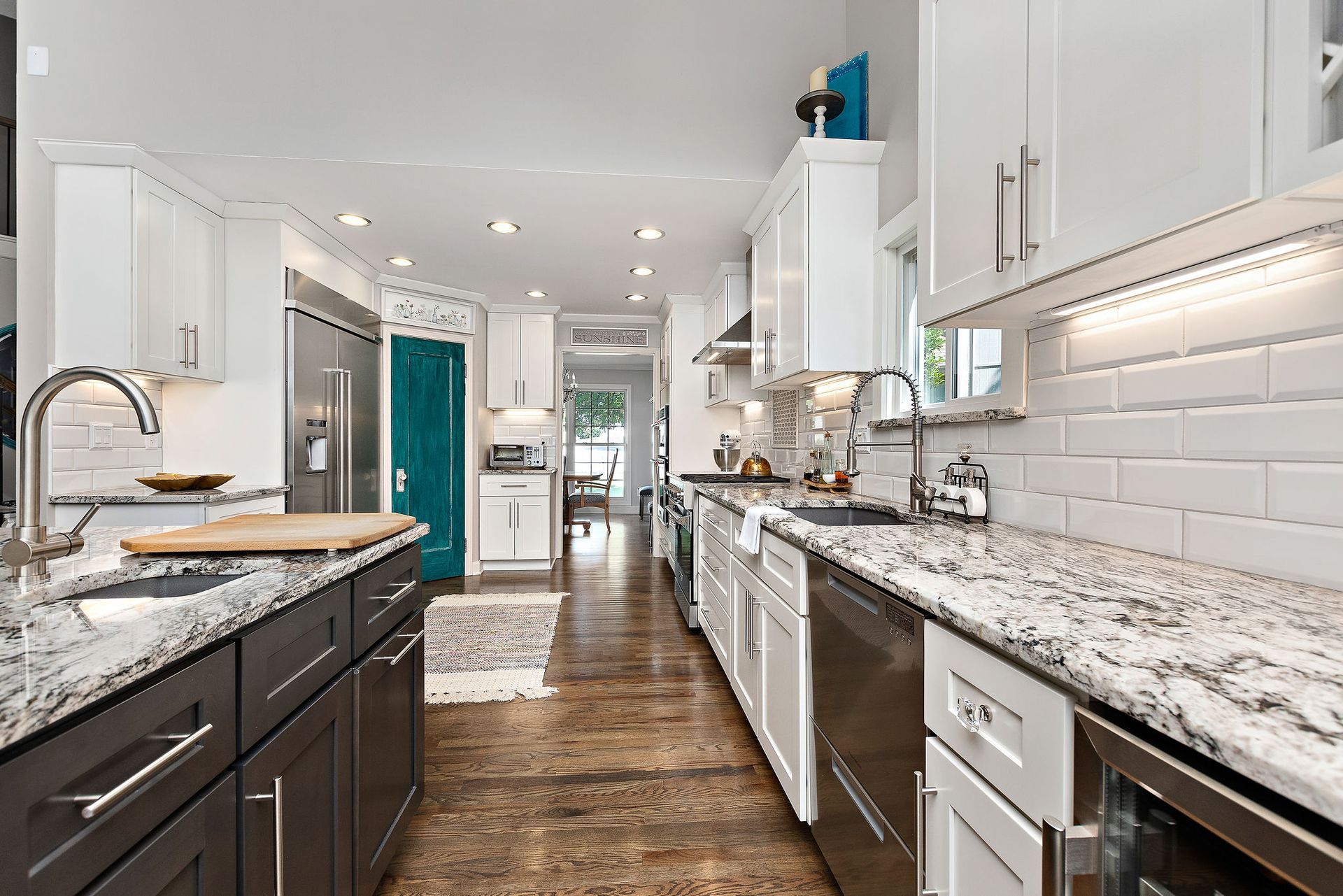 A kitchen with granite counter tops and stainless steel appliances.