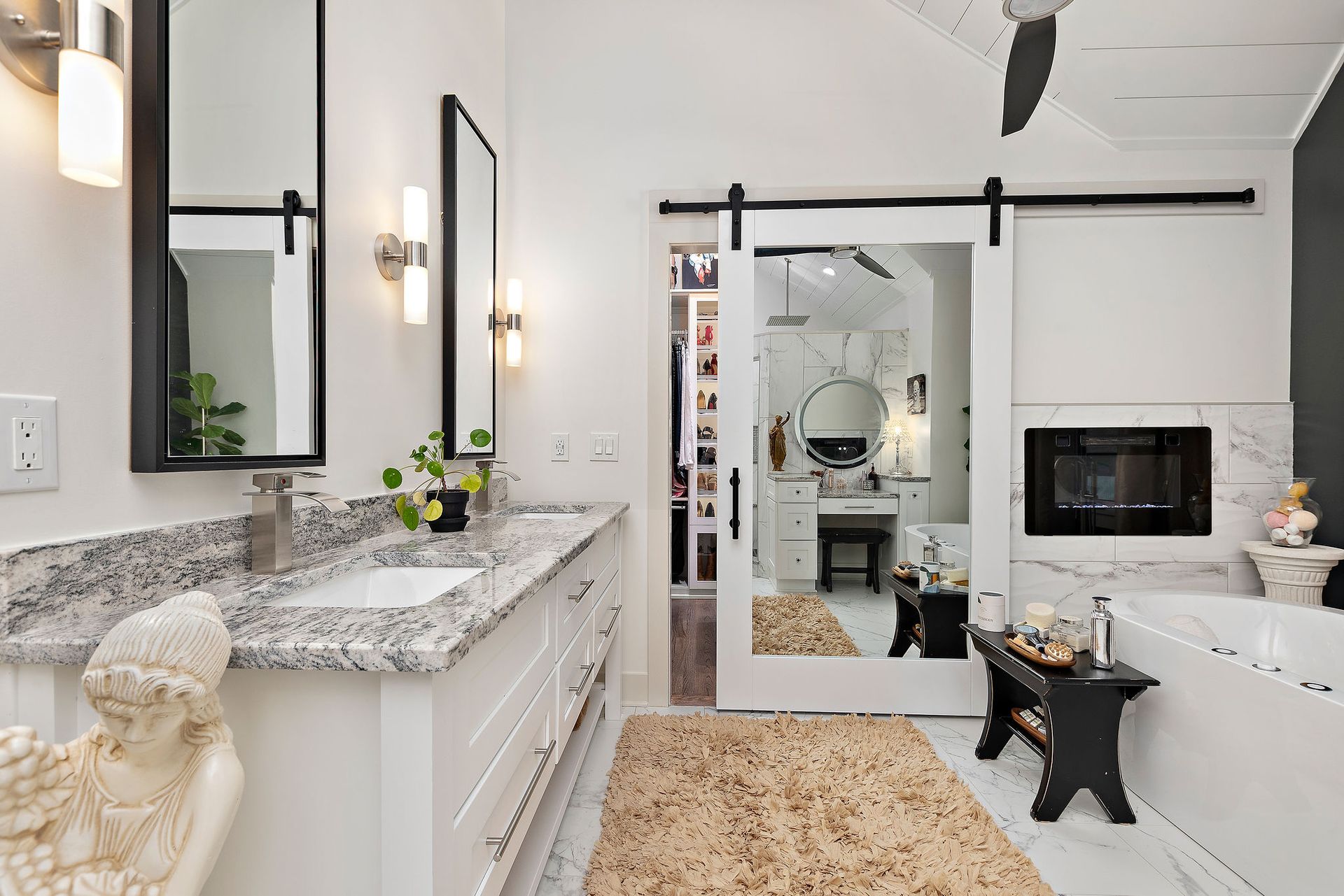 A bathroom with a sliding barn door and two sinks.