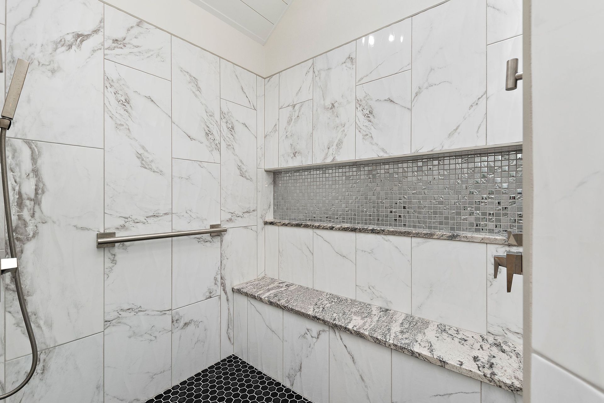 A bathroom with a walk in shower and a large mirror.