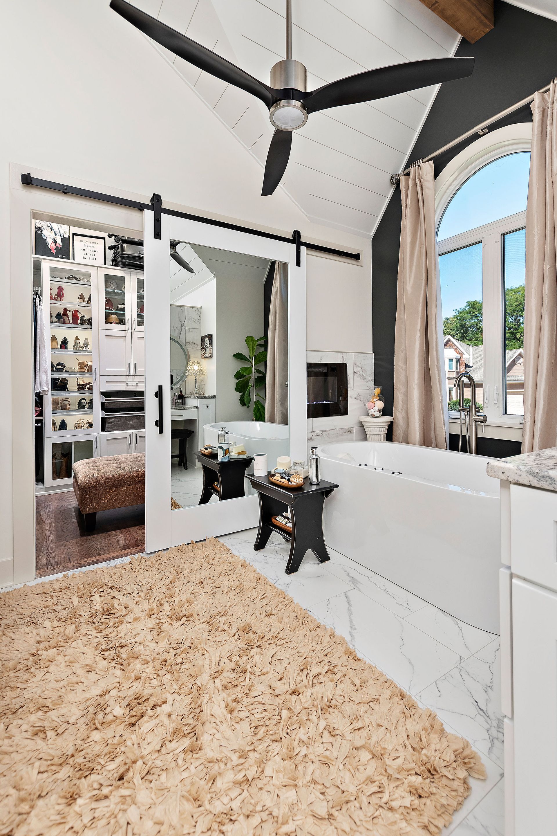 A bathroom with a bathtub and a ceiling fan.