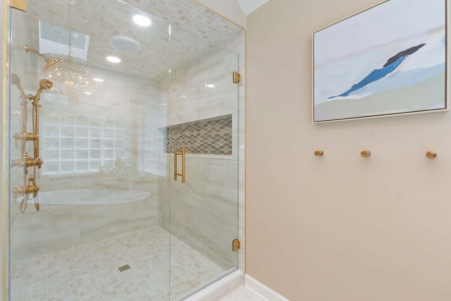 A bathroom with a walk in shower and a painting on the wall.