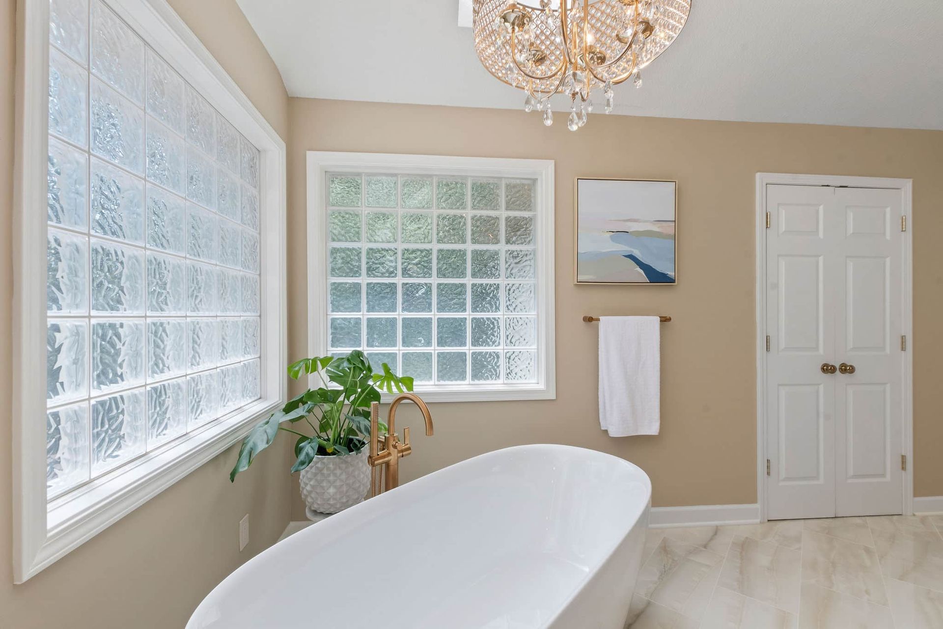 A bathroom with a bathtub and a chandelier hanging from the ceiling.
