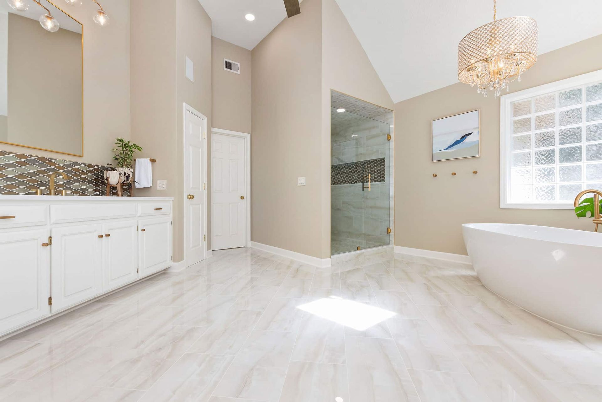 A bathroom with a tub , sink , mirror and shower.