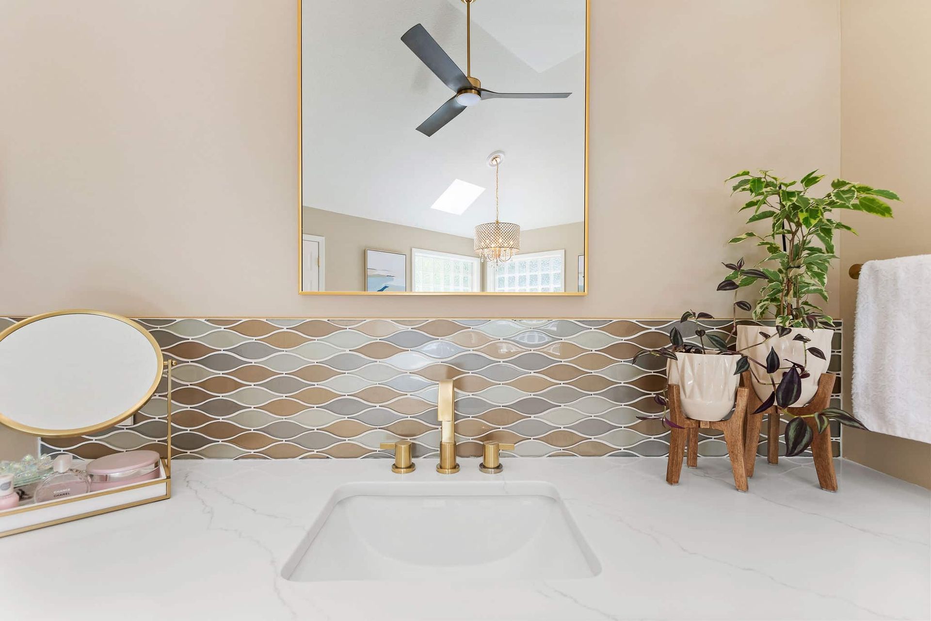 A bathroom with a sink , mirror , and ceiling fan.