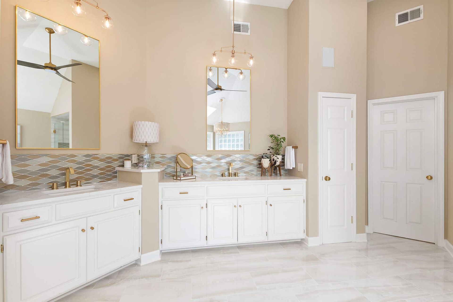A bathroom with two sinks , a mirror and a ceiling fan.