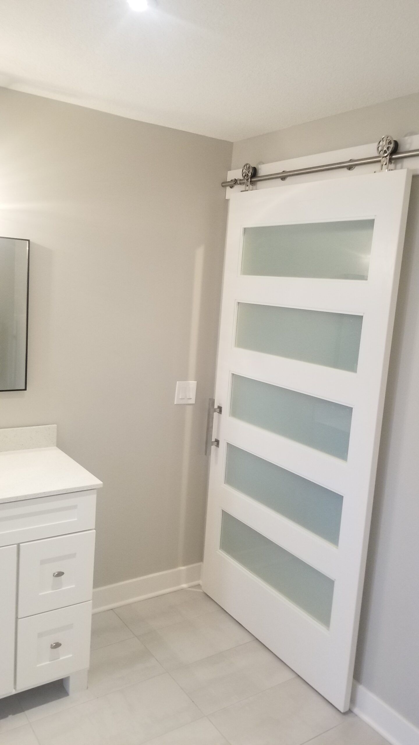 A bathroom with a sliding barn door and a vanity.