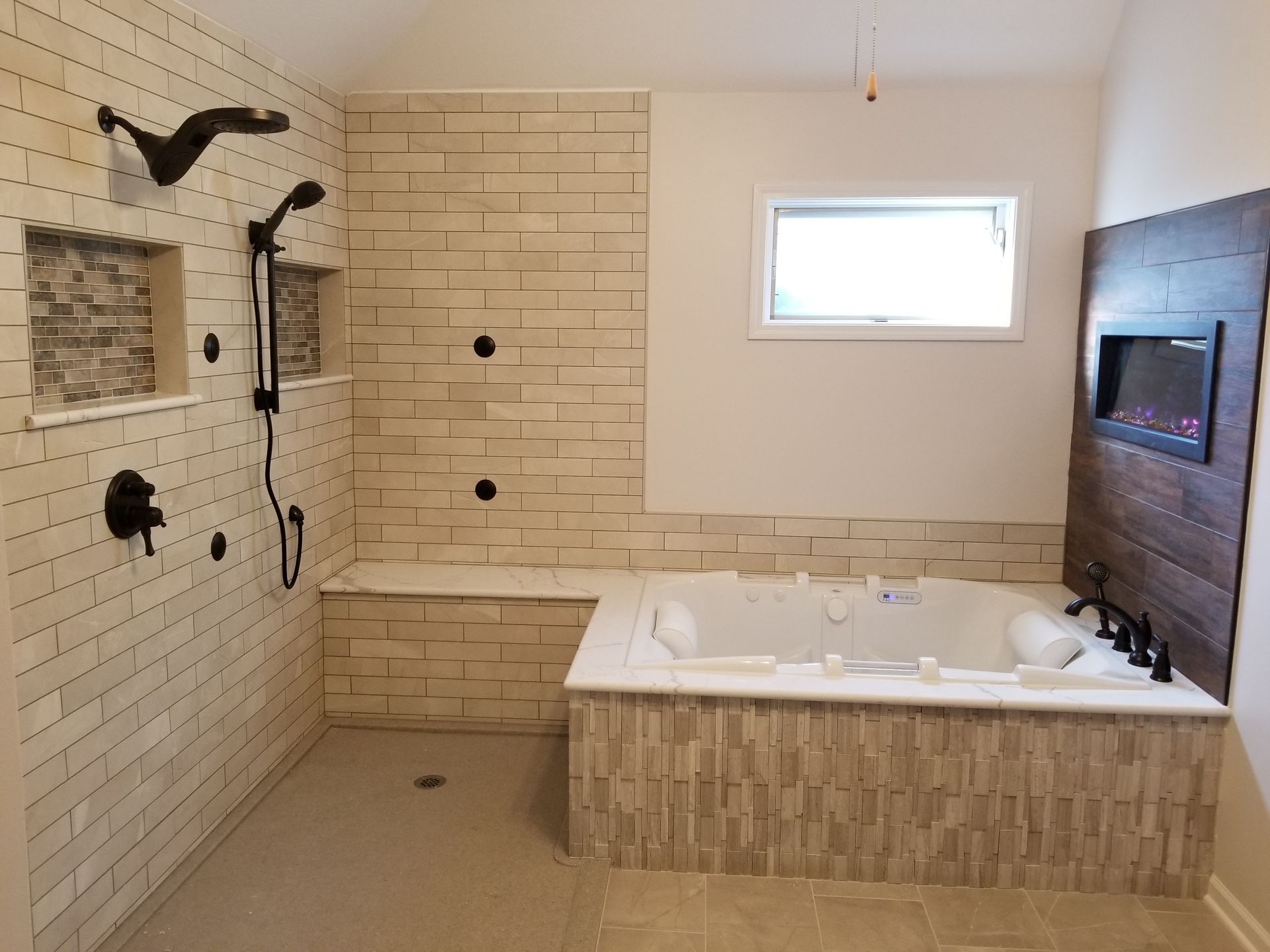 A bathroom with a tub , shower , and fireplace.