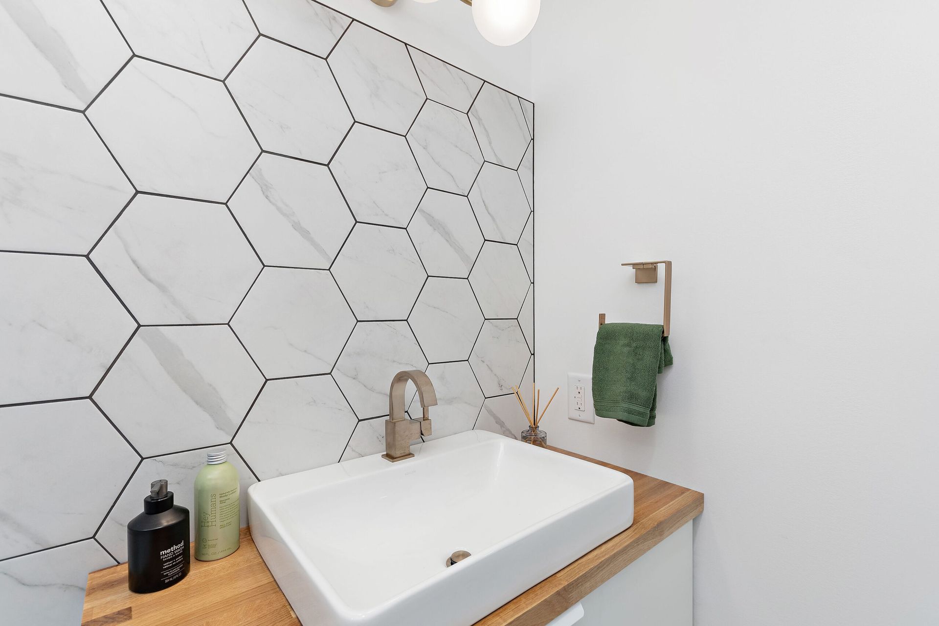 A bathroom with a sink and a wooden counter top.